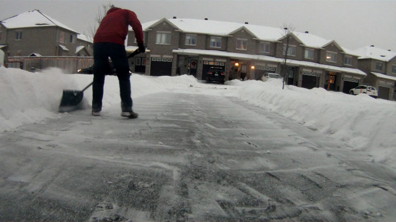 Professional movers clearing snow for safe winter moving